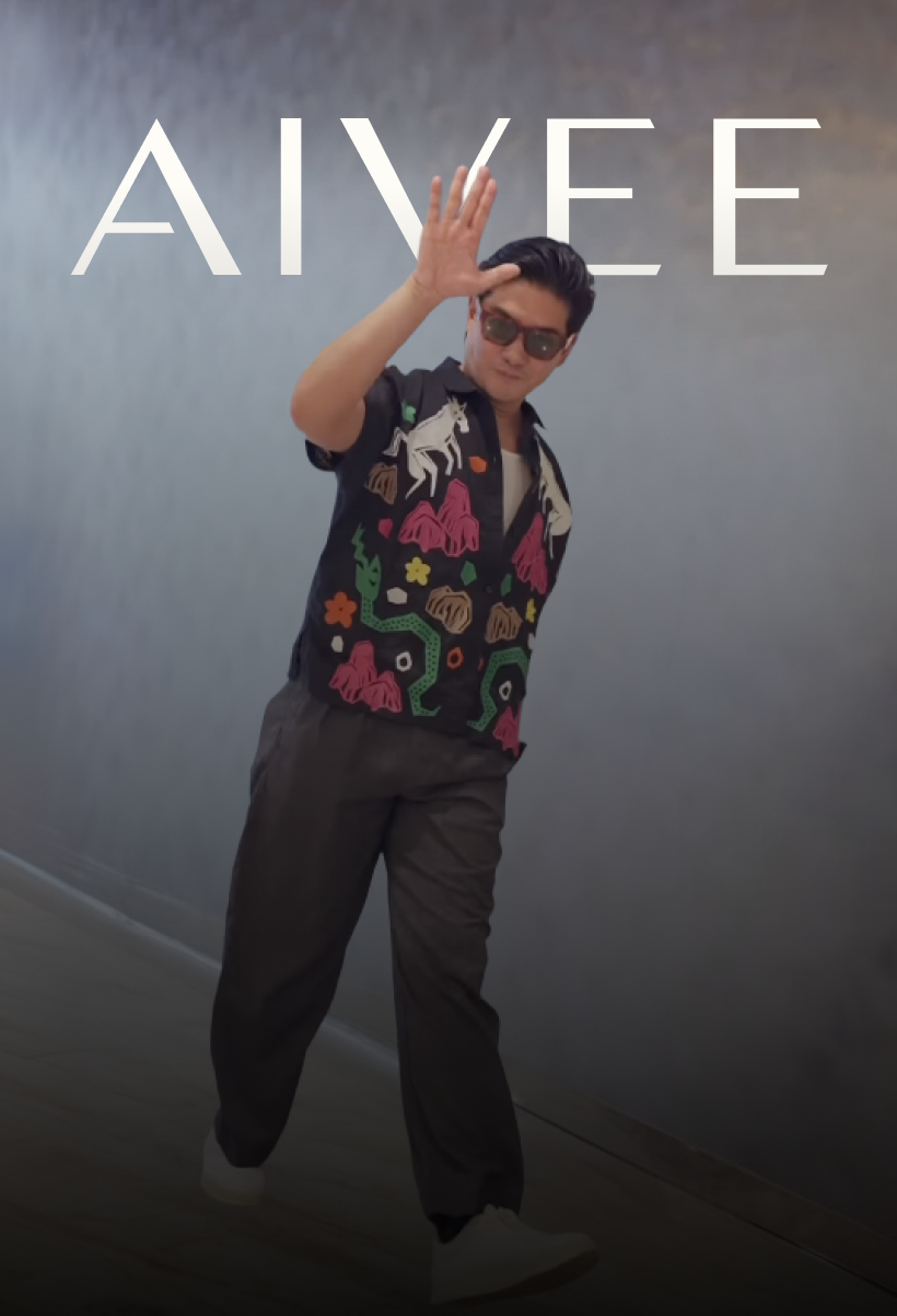 Tim Yap waving in sunglasses and a colorful patterned shirt against a gray wall